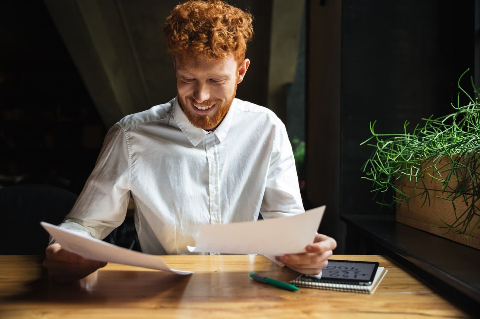 An owner smiling as he reads the survey results