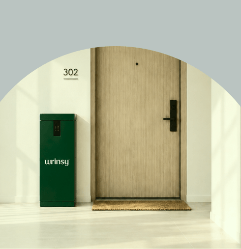 A wrinsy service box beside a resident door in a bright apartment hallway